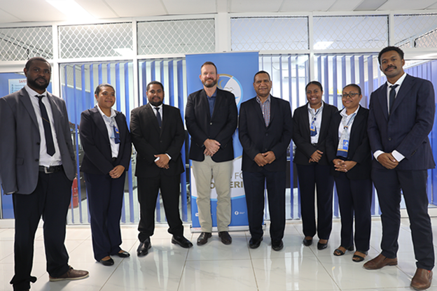 CEO, Neil Papenfus (center), PNG Ports Board Chairman, Harvey Nii (center-right) and Port Moresby-based graduates after their case study presentation